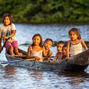 Enfants autochtones d'Orinoco nageant en pirogue traditionnelle en bois