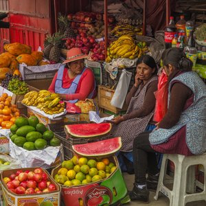 3 femmes boliviennes autour d'un stand de fruits et légumes, La Paz, Bolivie
