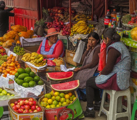 3 femmes boliviennes autour d'un stand de fruits et légumes, La Paz, Bolivie