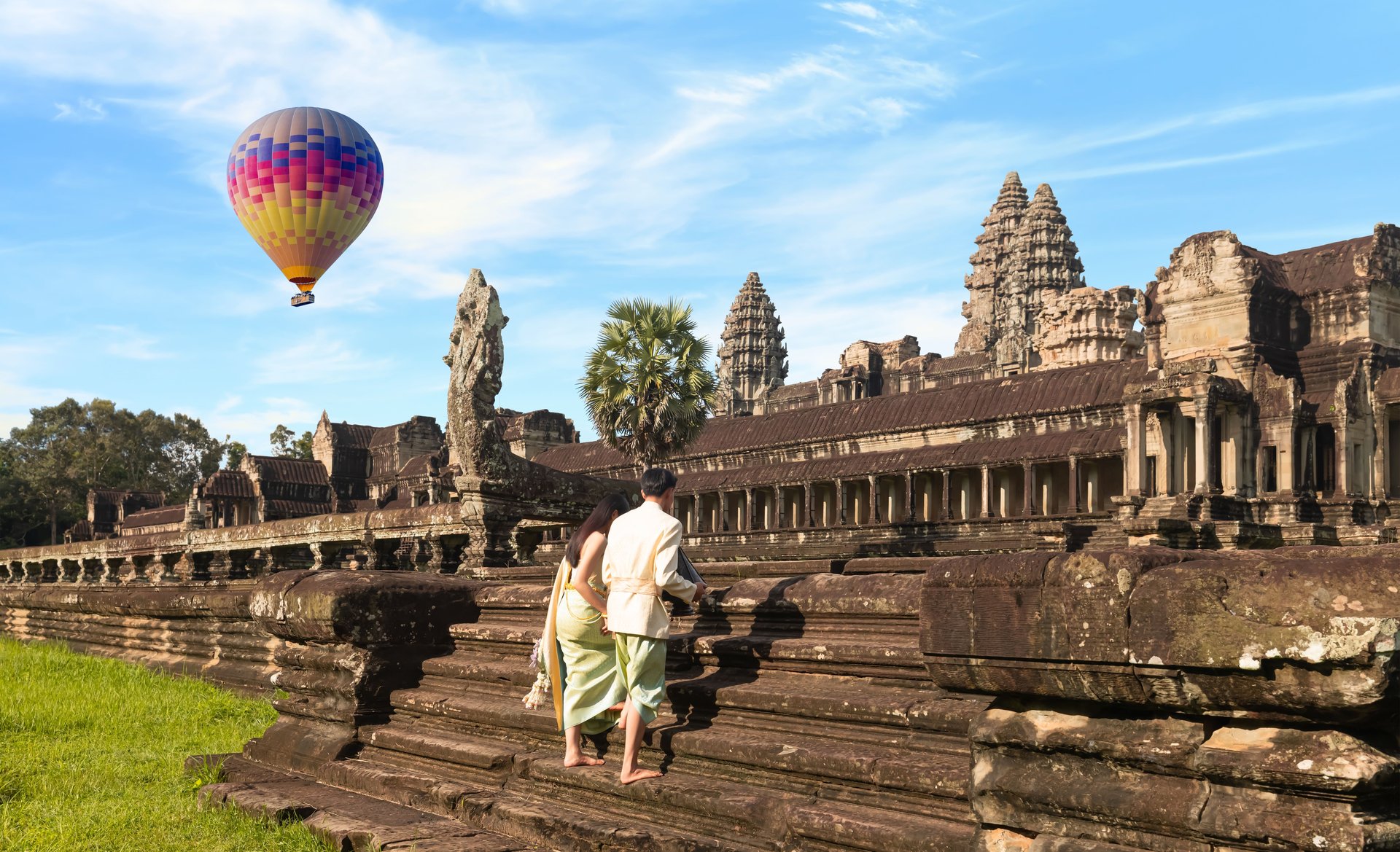 Couple devant le temple Angkor Vat avec vue sur une montgolfière au Cambodge