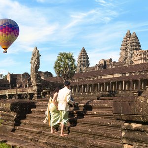 Couple devant le temple Angkor Vat avec vue sur une montgolfière au Cambodge