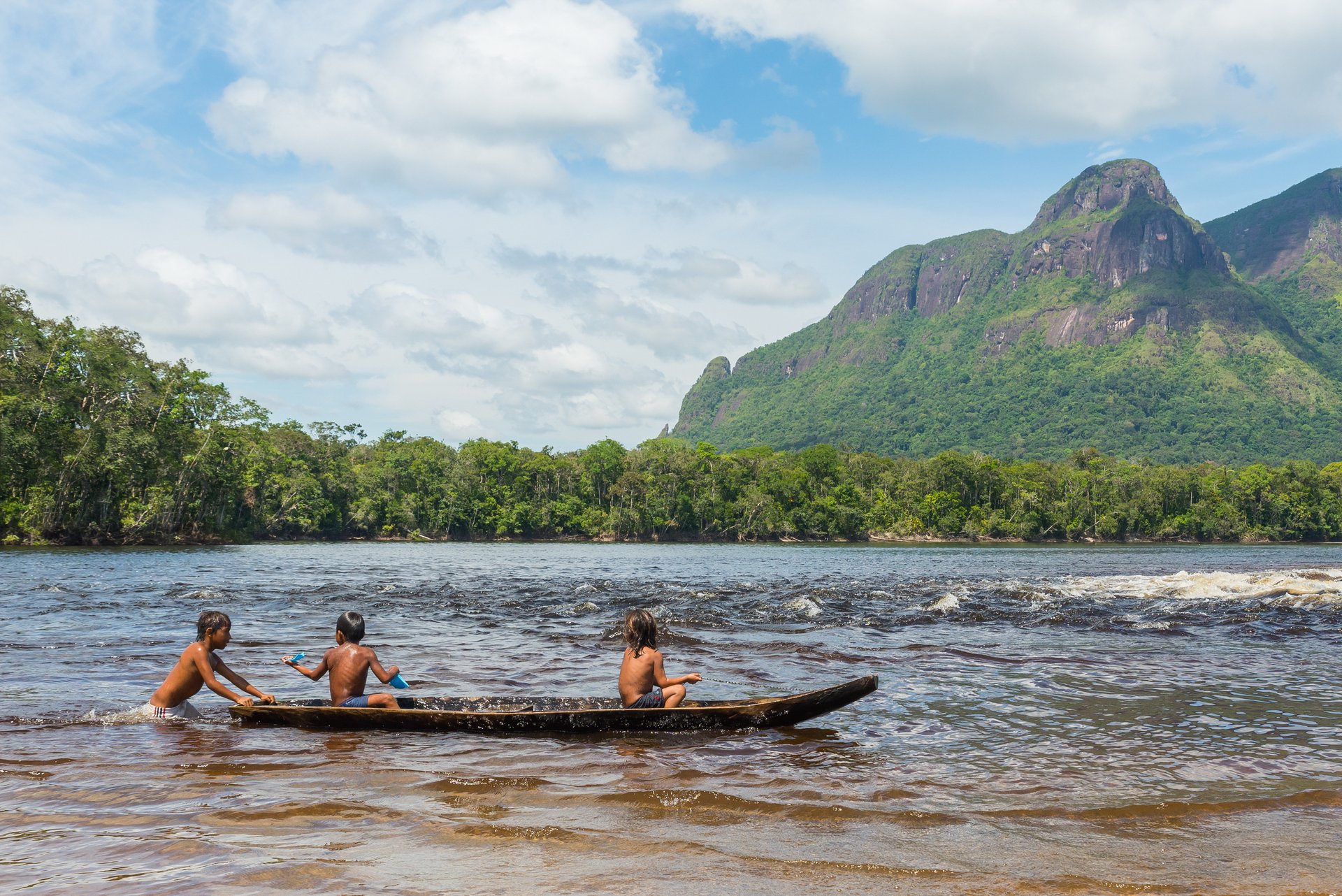 Des enfants de l'ethnie Piaroa jouent sur un canoë dans les eaux de la rivière Autana, dans l'état amazonas, au sud du Venezuela