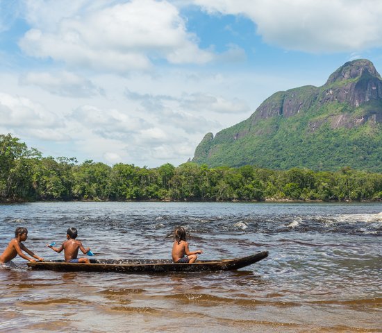 Des enfants de l'ethnie Piaroa jouent sur un canoë dans les eaux de la rivière Autana, dans l'état amazonas, au sud du Venezuela