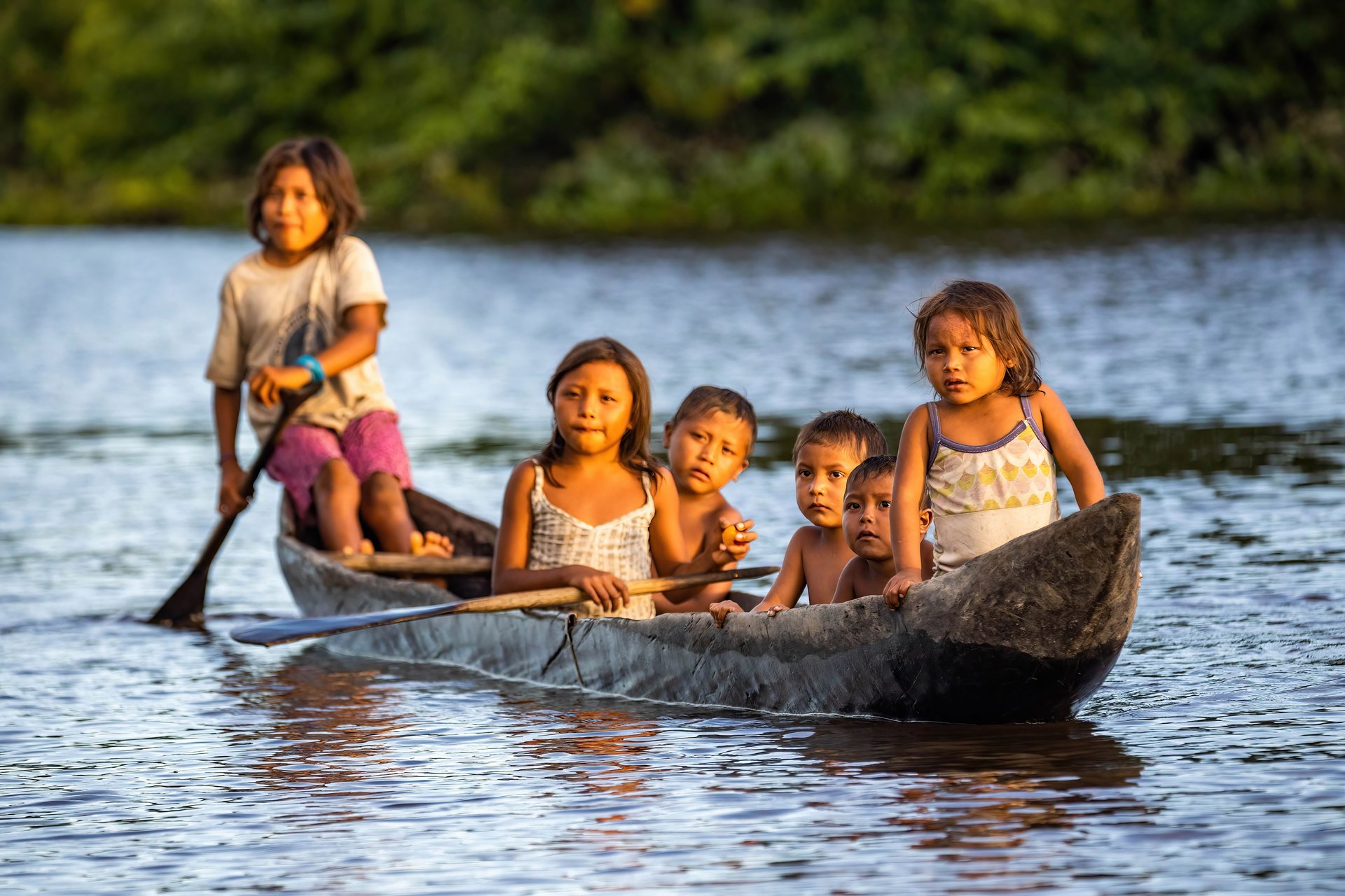 Enfants autochtones d'Orinoco nageant en pirogue traditionnelle en bois