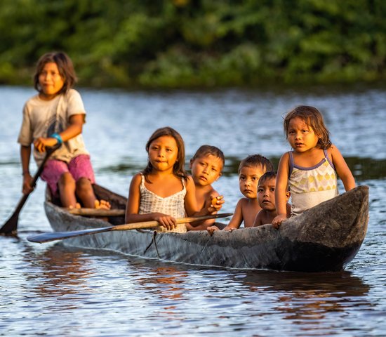 Enfants autochtones d'Orinoco nageant en pirogue traditionnelle en bois