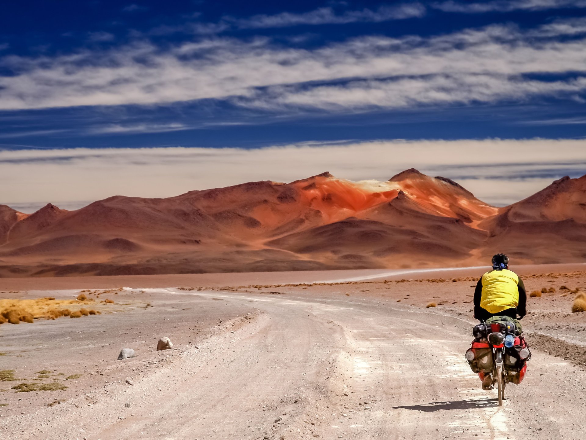 Homme qui fait du vélo devant le spectaculaire paysage de l'Altiplano en Bolivie