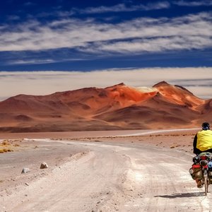 Homme qui fait du vélo devant le spectaculaire paysage de l'Altiplano en Bolivie