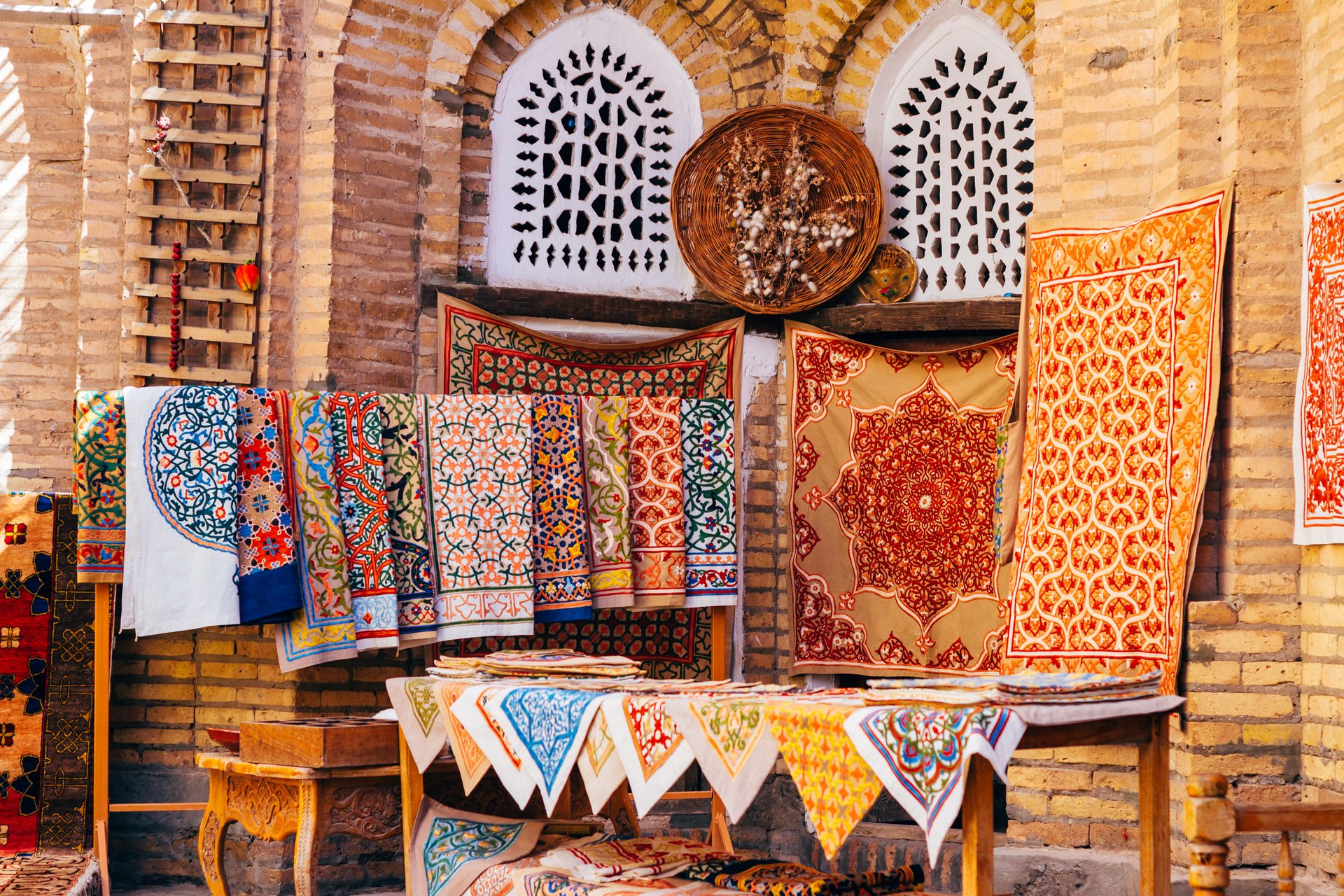 Large gamme de tapis faits à la main, les tapis de soie ouzbeks traditionnels noués, les nappes brodées et le linge de lit dans le petit bazar, Khiva, Ouzbékistan,