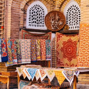 Large gamme de tapis faits à la main, les tapis de soie ouzbeks traditionnels noués, les nappes brodées et le linge de lit dans le petit bazar, Khiva, Ouzbékistan,