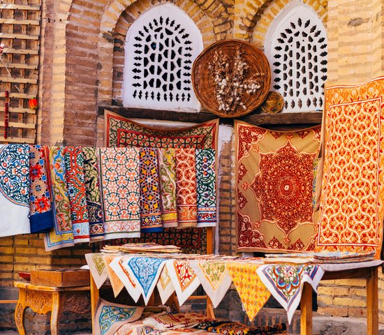 Large gamme de tapis faits à la main, les tapis de soie ouzbeks traditionnels noués, les nappes brodées et le linge de lit dans le petit bazar, Khiva, Ouzbékistan,