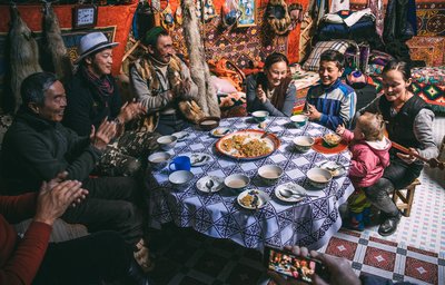 Nuit chez l'habitant  famille mange autour d'une tabel   Mongolie Shutterstocks