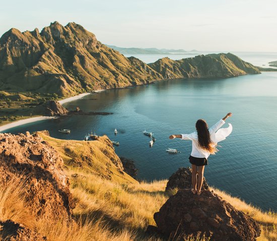 Une femme avec une vue imprenable sur l'île de Padar dans le parc national de Komodo, en Indonésie