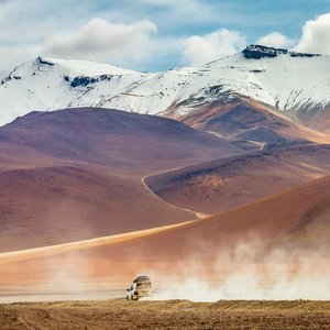 Voiture traversant une route de terre dans le désert d'Atacama, Bolivie