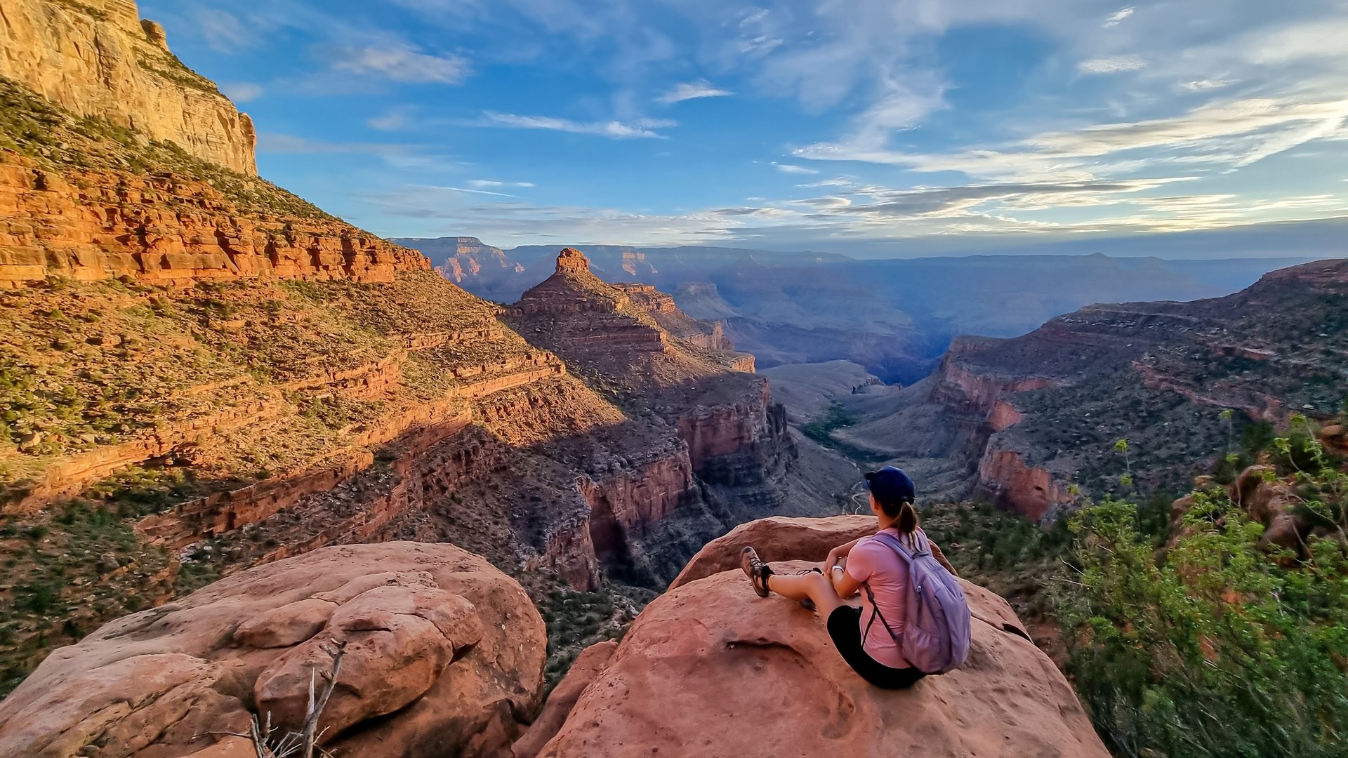Vue arrière d'une femme avec sac à dos assise sur un rocher le long du sentier Bright Angel avec vue aérienne sur South Rim of Grand Canyon National Park, Arizona, États Unis