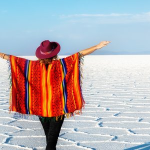 Une fille en chapeau et en poncho devant le Salar d'Uyuni, Bolivie