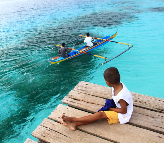 enfant assis avec vue sur la mer d'ambon indonesie