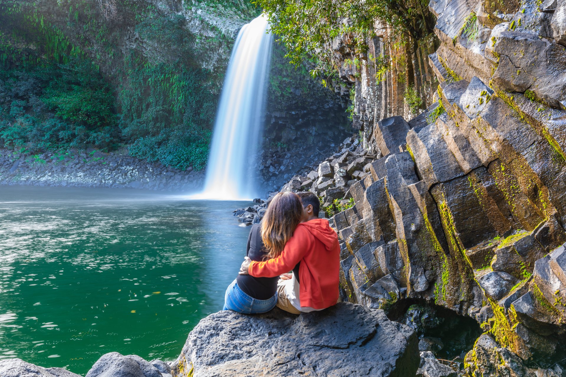 Un couple assis devant la cascade de la paix sur l'île de la Réunion