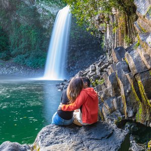 Un couple assis devant la cascade de la paix sur l'île de la Réunion