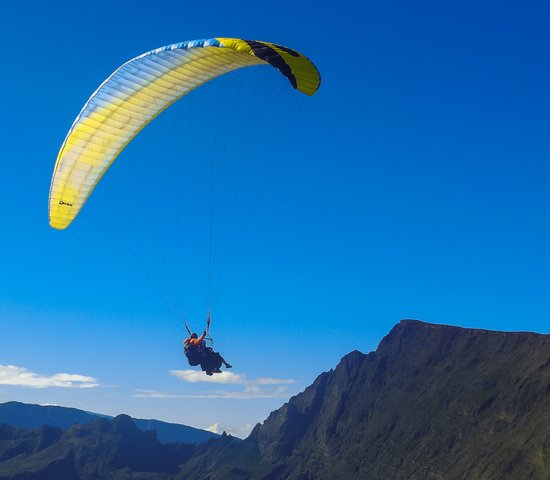 Parapente dans le ciel bleu de l'île de la Réunion, au sommet du Maido