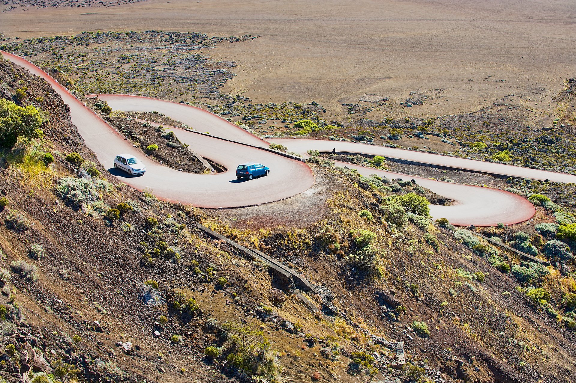 Des voitures passent par la route traversant la Plaine des Sables à 2260 m d'altitude près du volcan Piton de la Fournaise à Saint Paul De La Réunion, France.