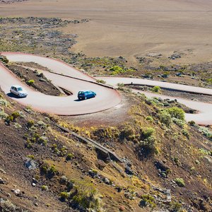 Des voitures passent par la route traversant la Plaine des Sables à 2260 m d'altitude près du volcan Piton de la Fournaise à Saint Paul De La Réunion, France.