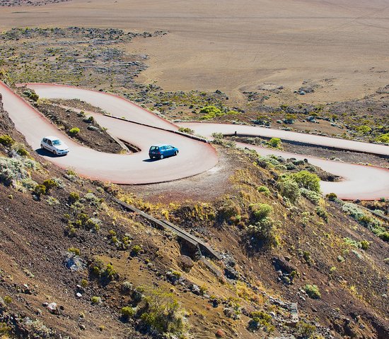 Des voitures passent par la route traversant la Plaine des Sables à 2260 m d'altitude près du volcan Piton de la Fournaise à Saint Paul De La Réunion, France.