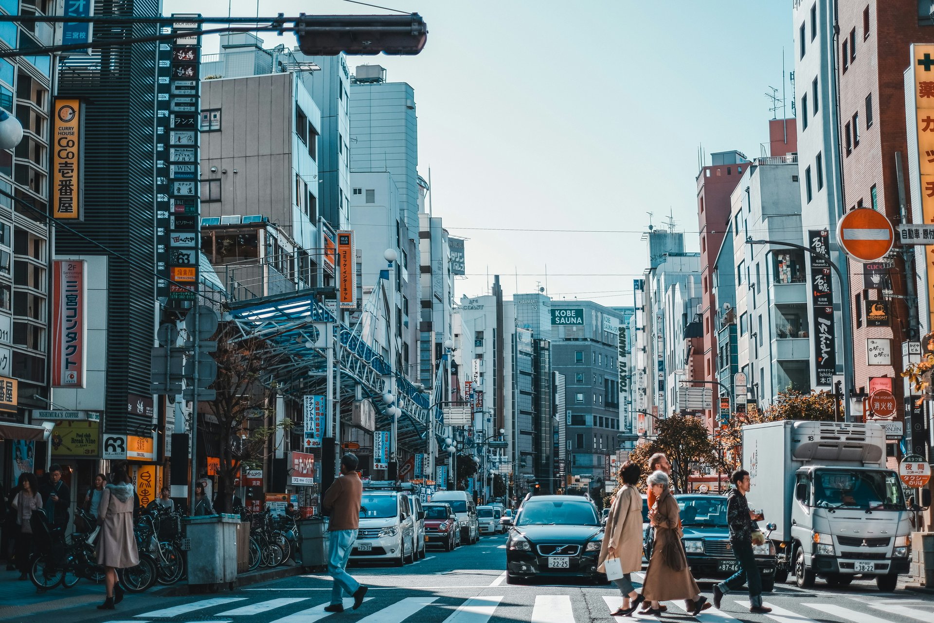 Passants sur un passage piétons, entourés d'immeubles dans la ville de Kobe, Japon